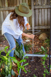 Woman using a compost aerator on a ground soil
