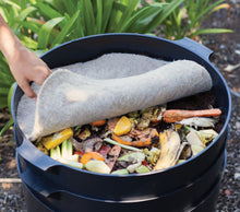 Round compost blanket covers a bin filled with organic materials